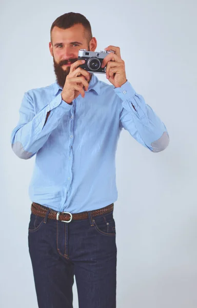 Young beard man focusing at you with his camera while standing — Stock Photo, Image