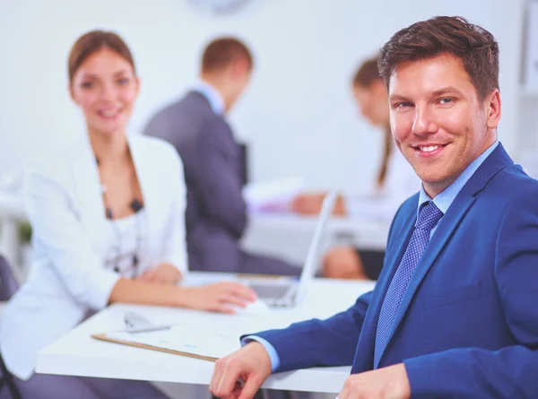 Hermosos jóvenes empresarios con colegas discutiendo en el fondo — Foto de Stock