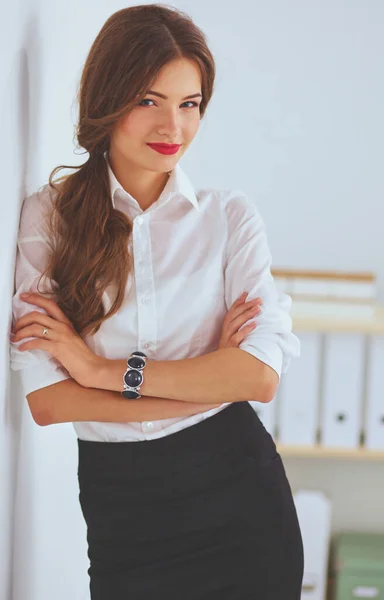 Attractive businesswoman with her arms crossed standing in off — Stock Photo, Image