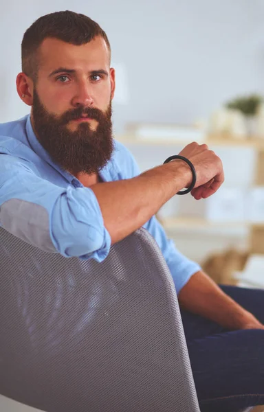 Jonge zakenman zit op stoel in functie — Stockfoto