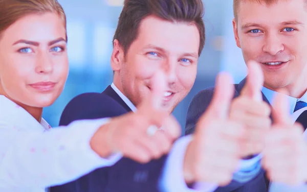 Feliz equipo de negocios mostrando pulgares hacia arriba en la oficina — Foto de Stock