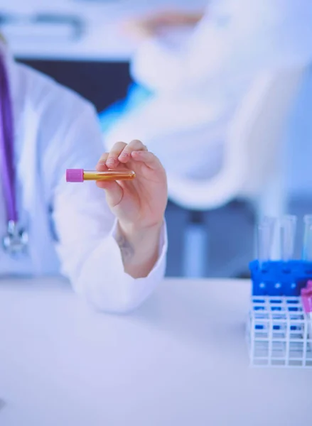 Laborassistentin Pholding Reagenzglas, Nahaufnahme mit Fokus auf die Röhrchen mit Tests. — Stockfoto
