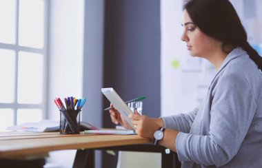 Ofiste modern dijital tablet kullanan güzel bir bayan yönetici..