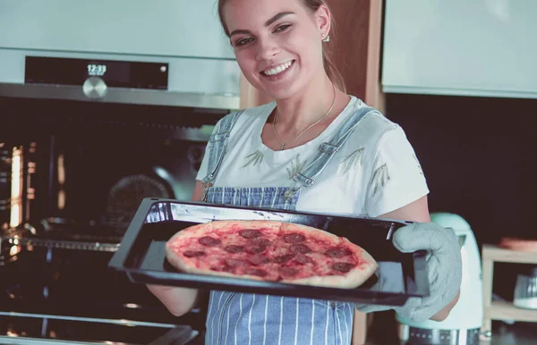 Ευτυχισμένη νεαρή γυναίκα μαγειρεύει πίτσα στο σπίτι — Φωτογραφία Αρχείου