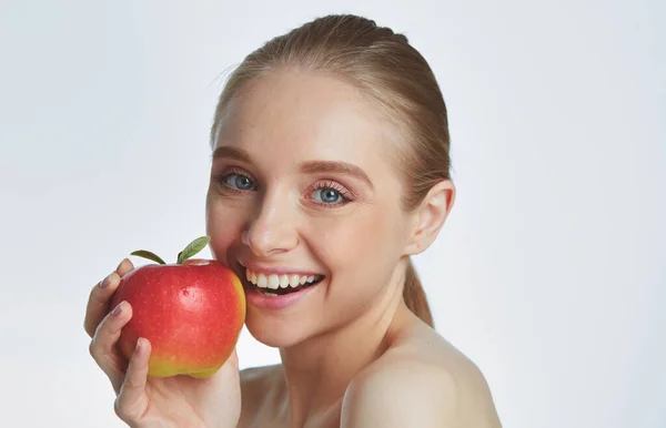 Portret van gelukkig lachend jonge mooie vrouw rode appel, eten over grijze achtergrond — Stockfoto