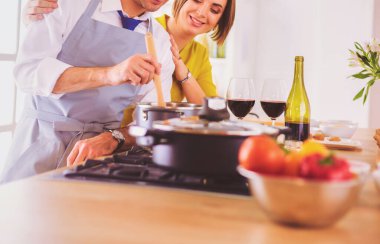 Aşık çekici bir çift yemek pişirir ve onlar romantik bir akşam yemeği pişirirken mutfakta şarap açar.