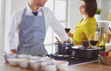 Aşık çekici bir çift yemek pişirir ve onlar romantik bir akşam yemeği pişirirken mutfakta şarap açar.