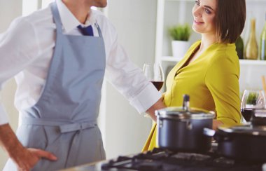 Aşık çekici bir çift yemek pişirir ve onlar romantik bir akşam yemeği pişirirken mutfakta şarap açar.