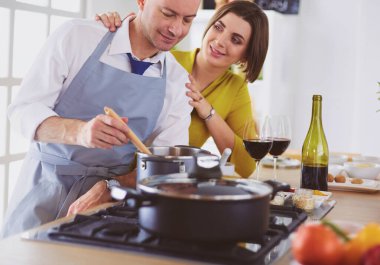 Aşık çekici bir çift yemek pişirir ve onlar romantik bir akşam yemeği pişirirken mutfakta şarap açar.