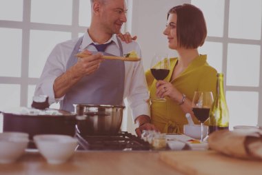 Aşık çekici bir çift yemek pişirir ve onlar romantik bir akşam yemeği pişirirken mutfakta şarap açar.