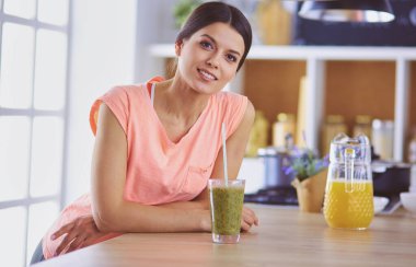 Mutfakta masada oturan genç bir kadın.