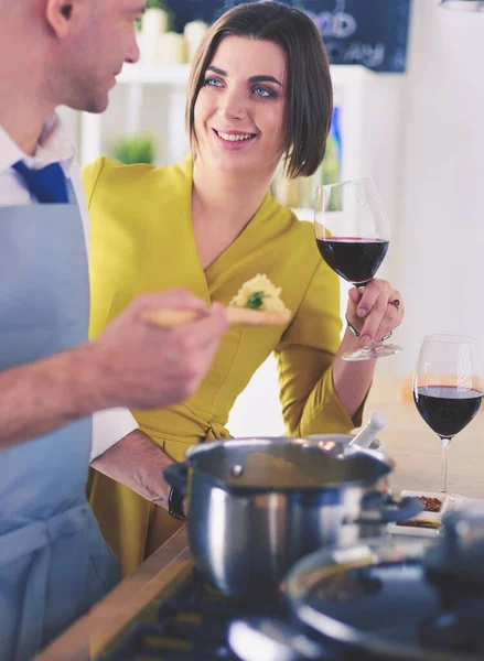 Atraktivní pár v lásce vaření a otevírá víno v kuchyni, zatímco oni vaří večeři pro romantický večer — Stock fotografie