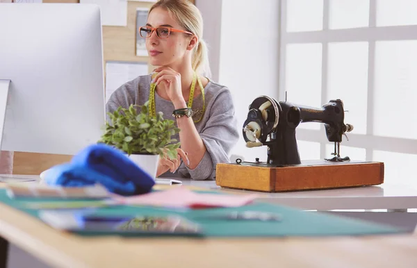 Vacker ung flicka i en fabrik med symaskin vid bordet — Stockfoto