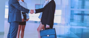 İki başarılı iş adamının el sıkışırken tam boy görüntüsü.