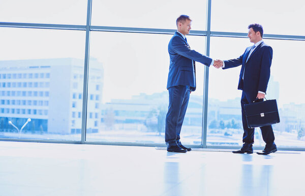 Изображение двух успешных бизнесменов, пожимающих друг другу руки
