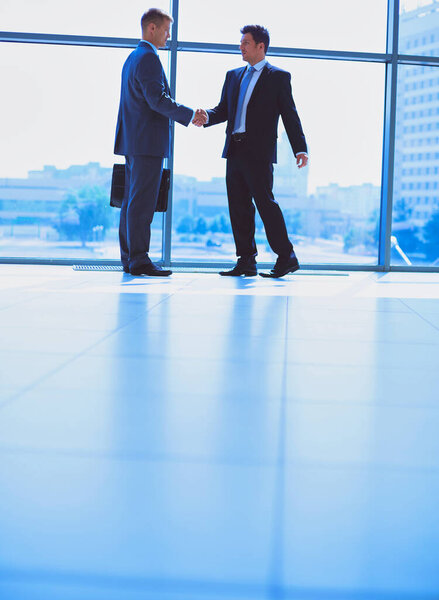 Изображение двух успешных бизнесменов, пожимающих друг другу руки