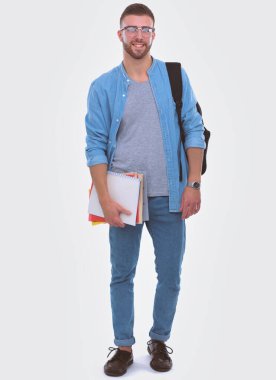 Beyaz arka plan üzerinde izole kitap tutan bir okul çantası ile bir erkek öğrenci. Eğitim olanakları. Üniversite öğrencisi.