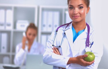 Yeşil bir elma tutan kadın doktor.
