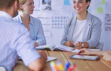 Masada kitaplarla çalışan gençler. Güzel kadınlar ve erkekler birlikte çalışıyor.