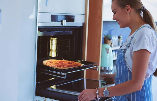 Gelukkig jong vrouw koken pizza thuis — Stockfoto