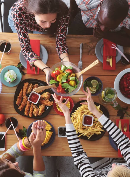 나무 테이블에 앉아 있는 동안 함께 저녁 식사 하는 사람들의 그룹 — 스톡 사진