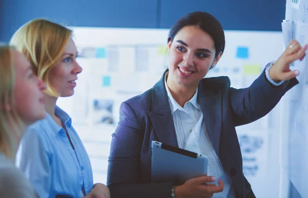 Business, education and office concept - business team with flip board in office discussing something. — Stock Photo, Image