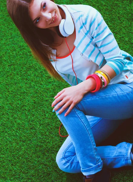 Jovem com laptop sentado na grama verde. Portreit jovem mulher — Fotografia de Stock