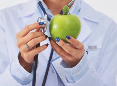 Doktor kadın elmayı steteskopla inceliyor. Kadın doktorlar