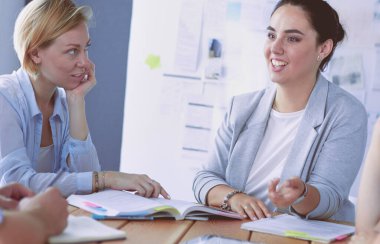 Masada kitaplarla çalışan gençler. Güzel kadınlar ve erkekler birlikte çalışıyor..