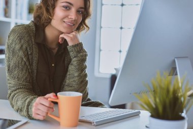 Öğrenci evdeki bir masada dizüstü bilgisayarla çalışıyor ve öğreniyor.