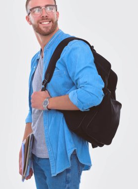 Beyaz arka plan üzerinde izole kitap tutan bir okul çantası ile bir erkek öğrenci. Eğitim olanakları. Üniversite öğrencisi.