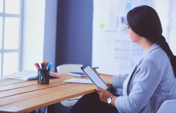 Muito jovem gerente do sexo feminino usando tablet digital moderno no escritório. — Fotografia de Stock