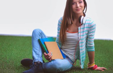 Yeşil çimlerde oturan genç bir kadın. Portreit genç bayan