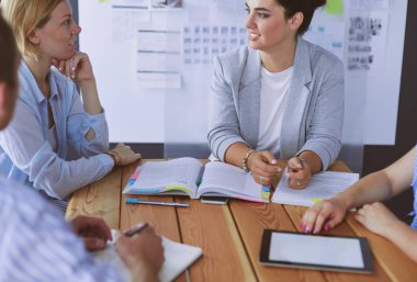 Masada kitaplarla çalışan gençler. Güzel kadınlar ve erkekler birlikte çalışıyor..