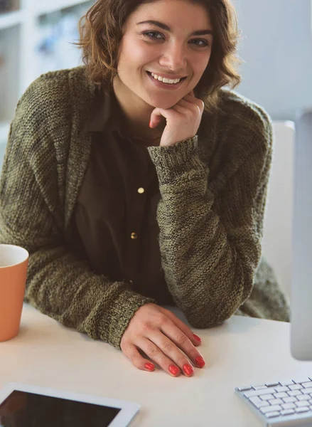 Öğrenci laptopla çalışıyor ve evdeki masada oturuyor.