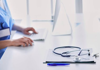 Masada oturan gülümseyen güzel genç bayan doktor..