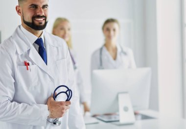 Tıbbi grubun önünde genç bir erkek doktor..