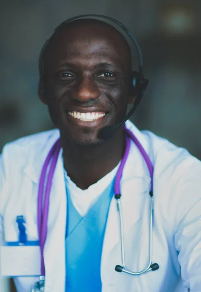 Klinikteki Masada Bilgisayar Kullanırken Kulaklık Takan Genç Erkek Doktorun Portresi — Stok fotoğraf