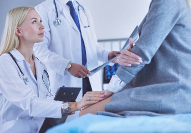 Doktor ve hasta tarama sonuçlarını tarama merkezinde tartışıyor.