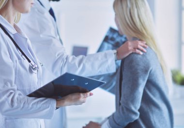 Doktor ve hasta tarama sonuçlarını tarama merkezinde tartışıyor.