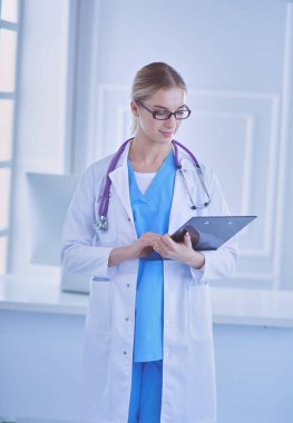Üniformalı bir dosyayla gülümseyen kadın doktor.