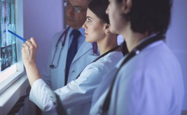 Bir grup doktor hastanede röntgenleri inceliyor.