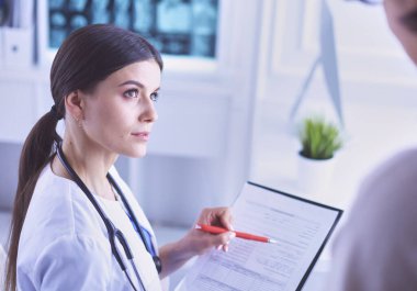 Güzel bayan doktor bir hastaya tıbbi tedaviyi açıklıyor.