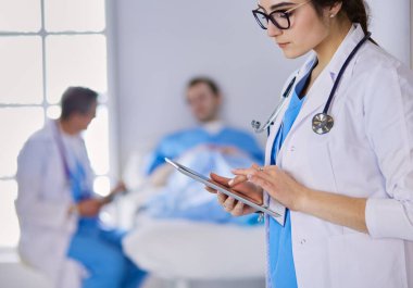 Hastane lobisinde tablet bilgisayar kullanan kadın doktor.,