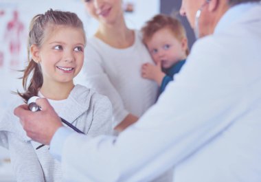 Steteskoplu kız ve doktor kalp atışlarını dinliyor..