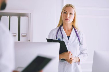 Kadın doktor hastanede dosyayla bekliyor..
