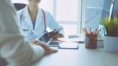 Bir doktor konuşuyor ve bir hastayı muayene ediyor..