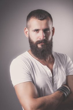 Ayakta, gri arka plan üzerinde izole yakışıklı adam portresi.