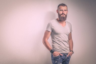 Ayakta, gri arka plan üzerinde izole yakışıklı adam portresi.