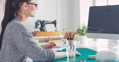 Moda tasarımcısının stüdyosunda çalışan portresi..